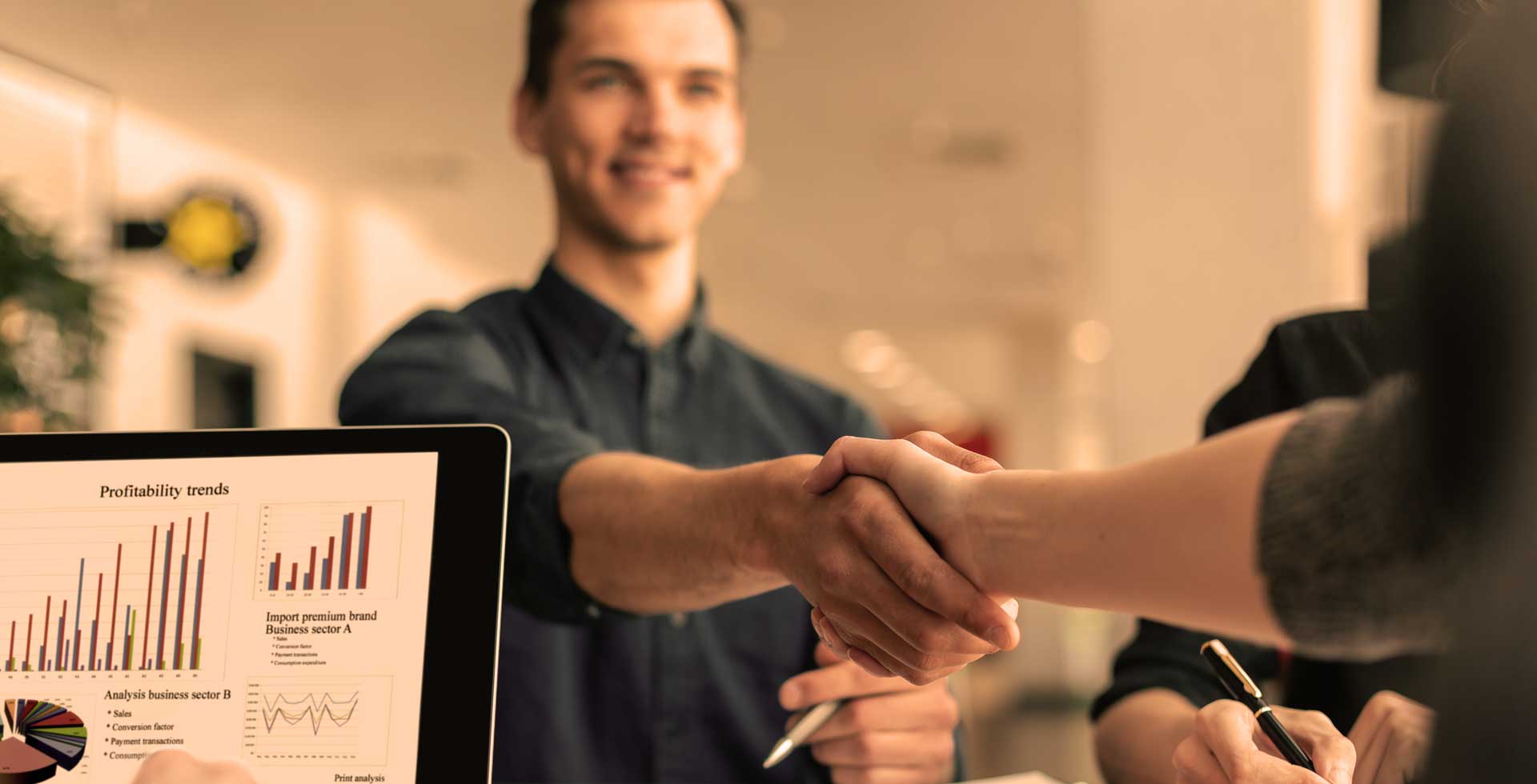 Profesionales estrechando manos en un acuerdo estratégico dentro de una oficina moderna.